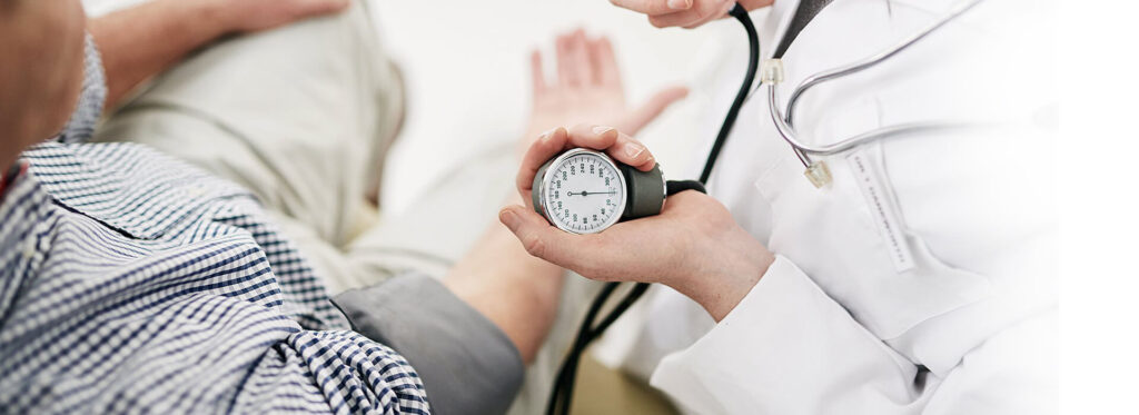 Doctor checking blood pressure for patient health in emergency room